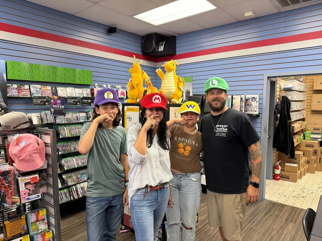 Brandt and his family wearing Mario-themed caps in a game store.